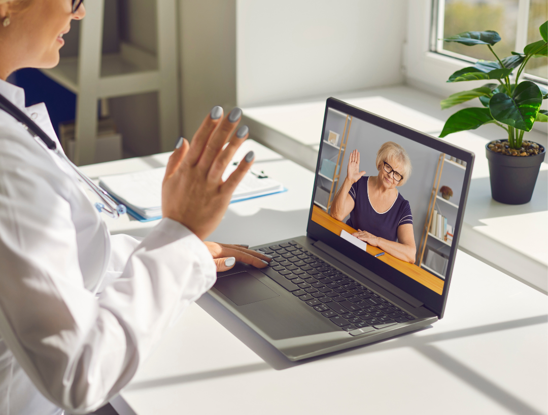 Patient smiling and waving at doctor during a telehealth video visit